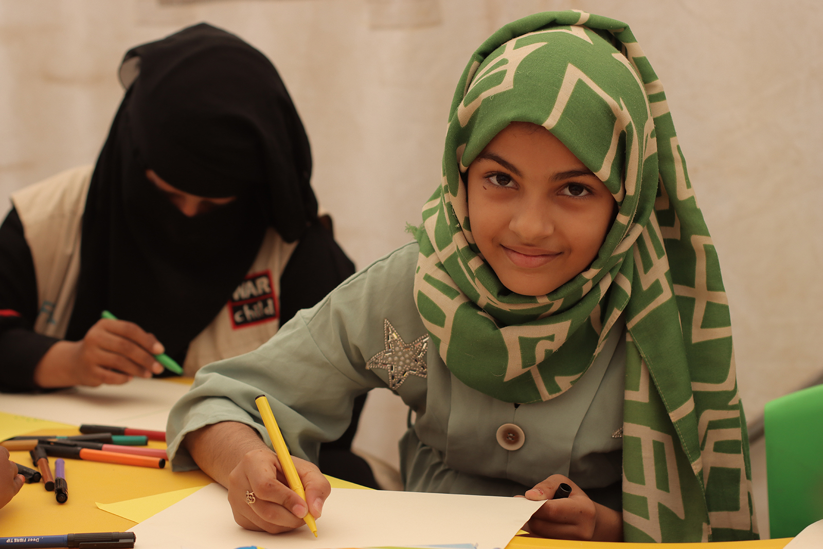 Kareema Saleh draws pictures at a child-friendly space in Al-Shathely camp in Al-Makha, Yemen, on 10 January 2022. COVID-19 has exacerbated existing conflict-driven vulnerabilities in Yemen. War Child Yemen continues to work on the ground empowering local
